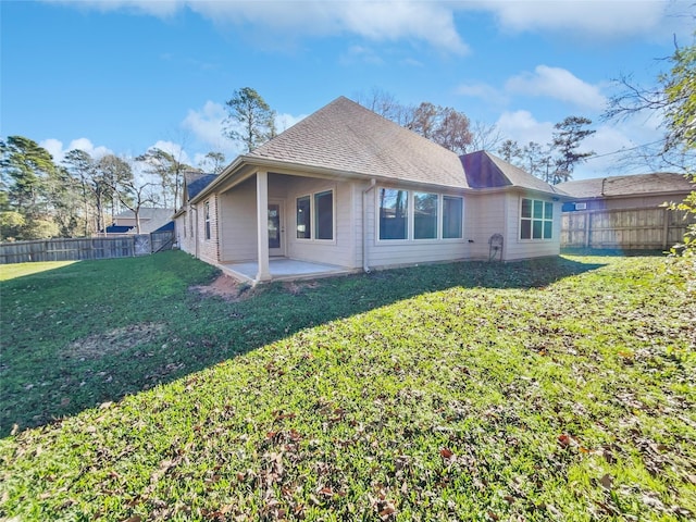 rear view of house with a lawn and a patio