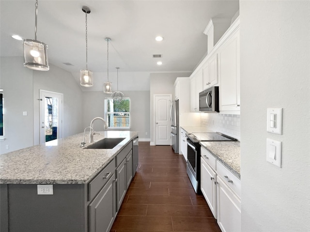 kitchen featuring sink, white cabinetry, stainless steel appliances, and an island with sink