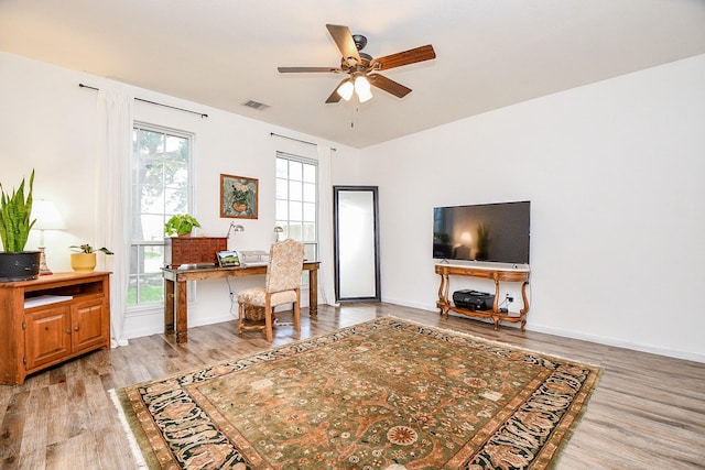 office area featuring light wood-type flooring, plenty of natural light, and ceiling fan