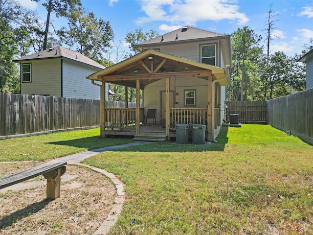 rear view of house featuring a deck, a yard, and central air condition unit