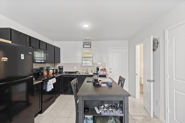 kitchen with a center island, light tile patterned flooring, black appliances, and sink