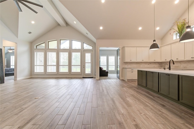 kitchen featuring decorative backsplash, light wood-type flooring, beamed ceiling, decorative light fixtures, and white cabinetry