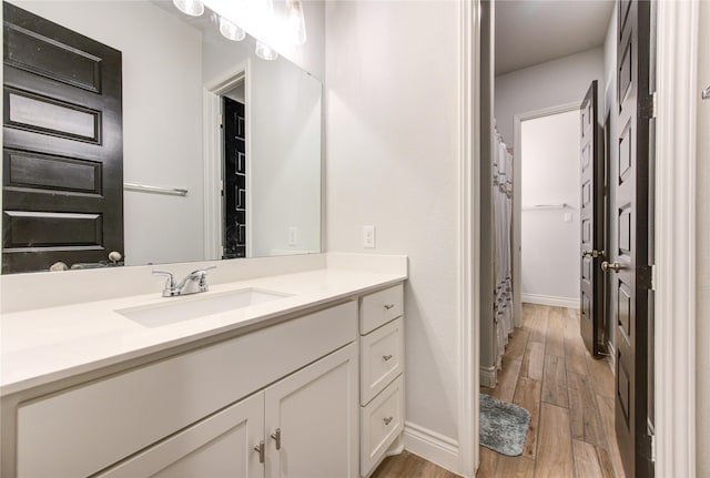 bathroom with a shower with curtain, hardwood / wood-style floors, and vanity