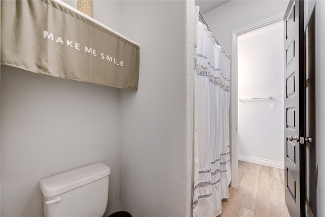 bathroom with wood-type flooring and toilet