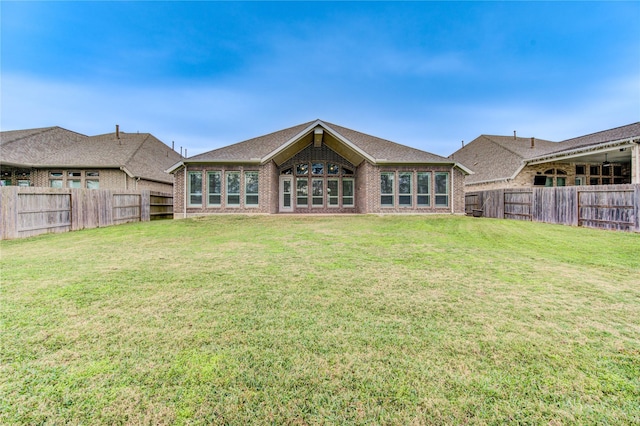 rear view of property featuring a lawn