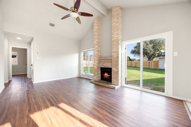 unfurnished living room featuring beamed ceiling, ceiling fan, dark hardwood / wood-style floors, and a brick fireplace