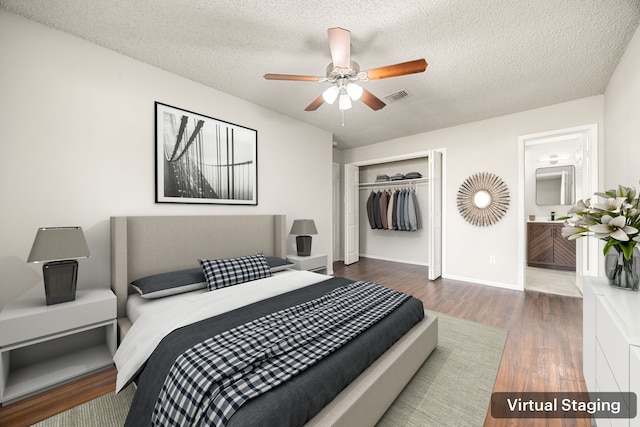 bedroom featuring ceiling fan, dark hardwood / wood-style flooring, ensuite bathroom, a textured ceiling, and a closet