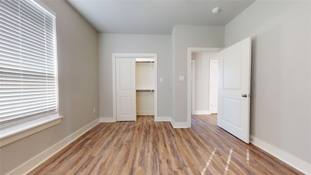 unfurnished bedroom featuring hardwood / wood-style flooring and a closet