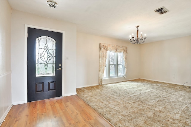 foyer entrance featuring wood-type flooring and an inviting chandelier