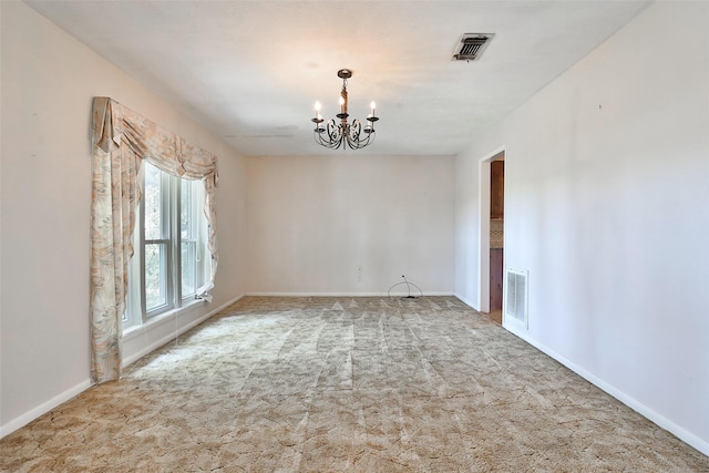 carpeted empty room featuring a notable chandelier