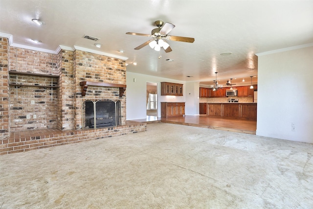 unfurnished living room featuring carpet, ceiling fan, ornamental molding, and a fireplace