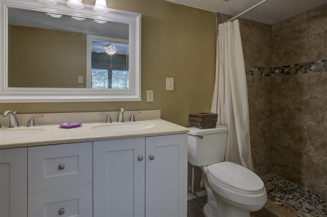 bathroom featuring ceiling fan, vanity, a shower with shower curtain, and toilet