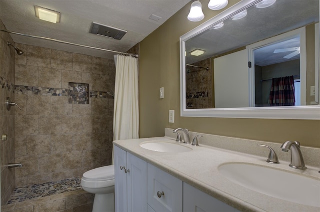 bathroom with vanity, a shower with shower curtain, a textured ceiling, and toilet