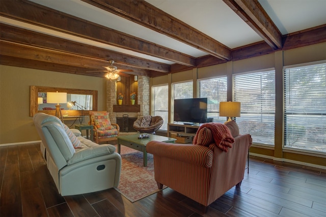 living room featuring beam ceiling, ceiling fan, and a brick fireplace