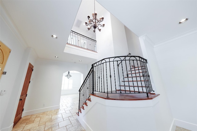 staircase featuring an inviting chandelier and ornamental molding