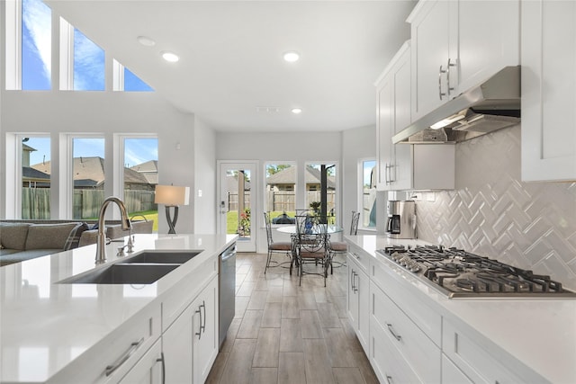 kitchen featuring decorative backsplash, white cabinetry, sink, and stainless steel appliances