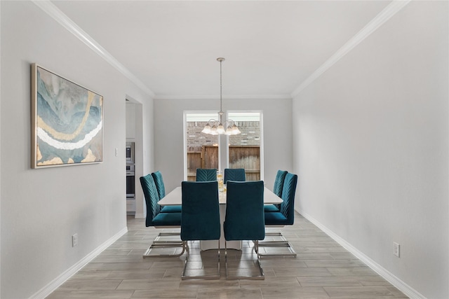 dining area with crown molding and a chandelier