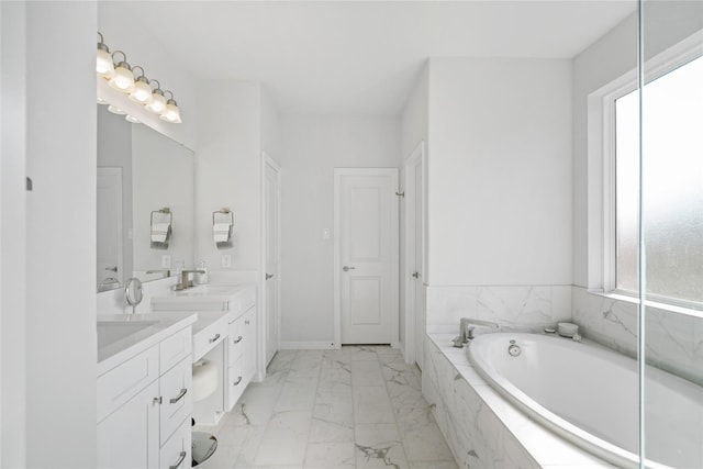 bathroom featuring plenty of natural light, a relaxing tiled tub, and vanity