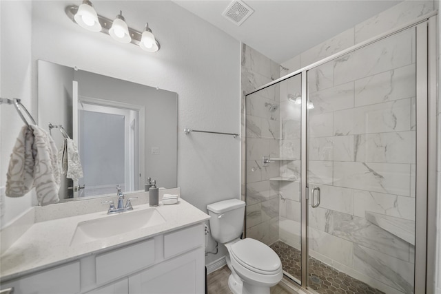 bathroom featuring wood-type flooring, vanity, a shower with shower door, and toilet