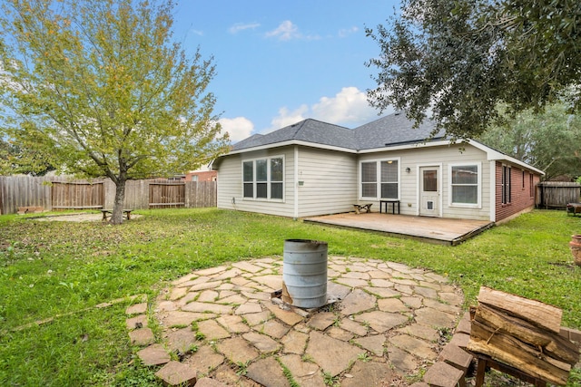 rear view of property with a yard and a deck