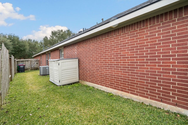 view of side of home with a yard and cooling unit