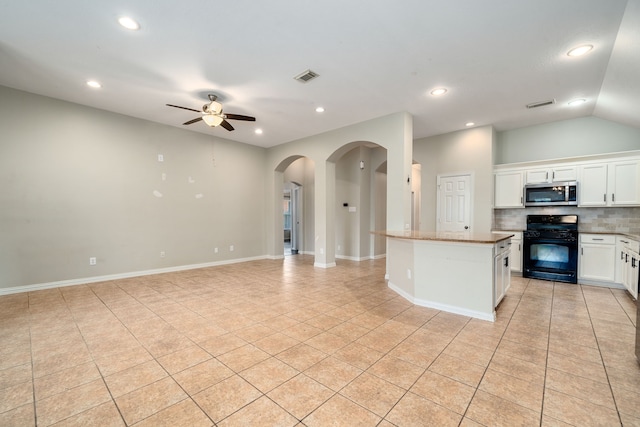 kitchen with ceiling fan, light tile patterned floors, white cabinets, black gas range, and a center island