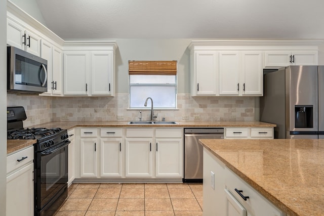 kitchen featuring light stone countertops, backsplash, stainless steel appliances, sink, and light tile patterned floors