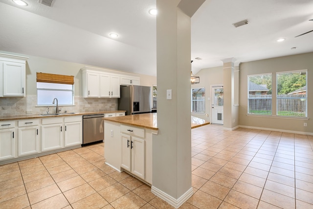 kitchen featuring white cabinetry, sink, stainless steel appliances, decorative backsplash, and light tile patterned floors