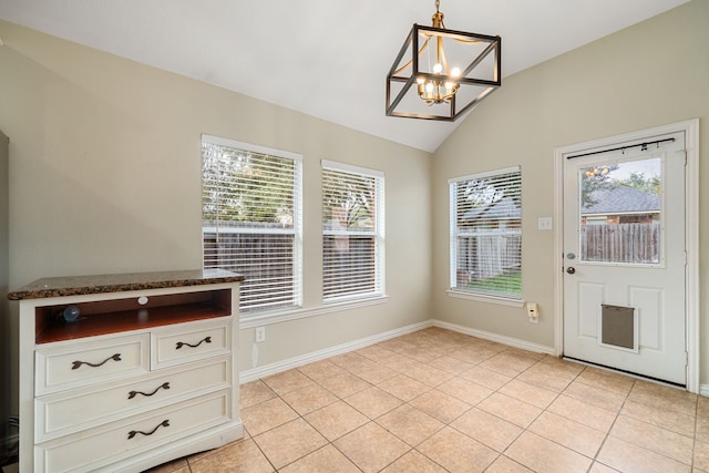 entryway featuring a wealth of natural light, light tile patterned floors, lofted ceiling, and an inviting chandelier