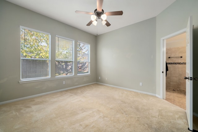 empty room featuring ceiling fan, a healthy amount of sunlight, and light carpet