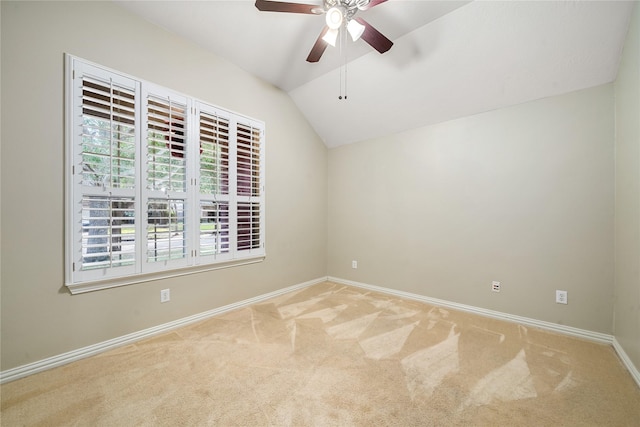 carpeted spare room with ceiling fan and vaulted ceiling