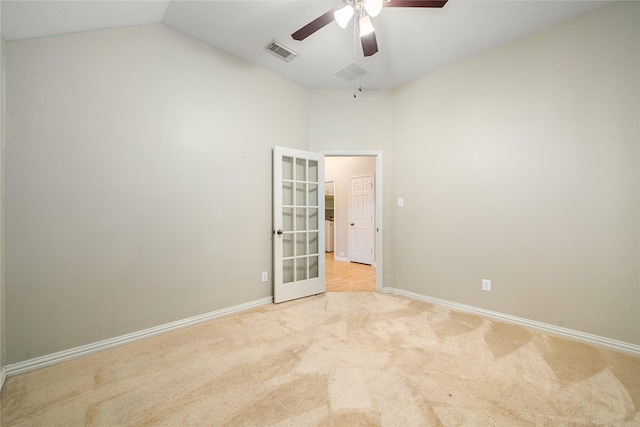 unfurnished room featuring light carpet, french doors, vaulted ceiling, and ceiling fan