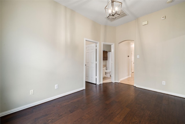 unfurnished room with a chandelier, wood-type flooring, and a high ceiling