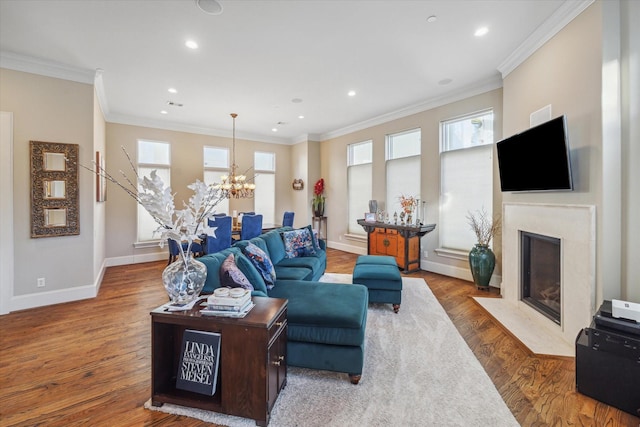 living room with plenty of natural light, crown molding, wood-type flooring, and a fireplace