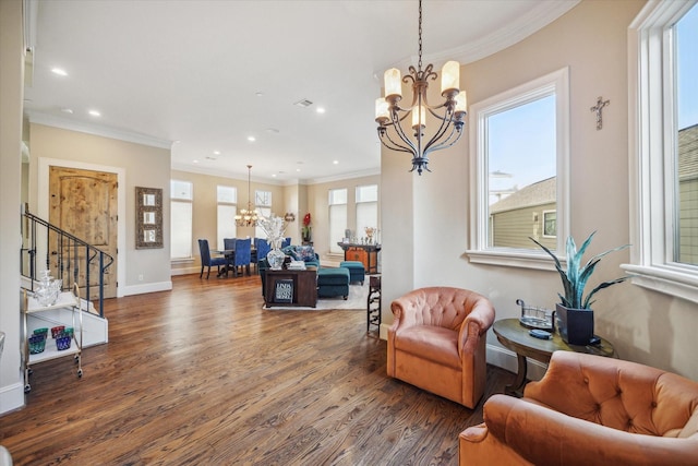 living room with dark hardwood / wood-style flooring, crown molding, a wealth of natural light, and a notable chandelier