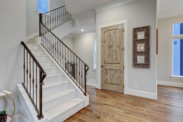 entryway with light wood-type flooring and ornamental molding