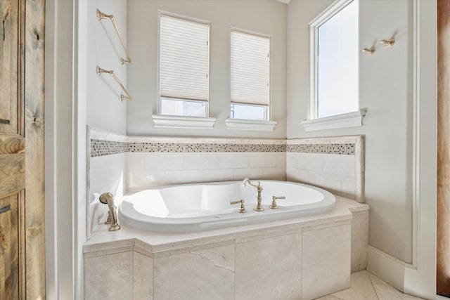 bathroom with tile patterned flooring and a relaxing tiled tub