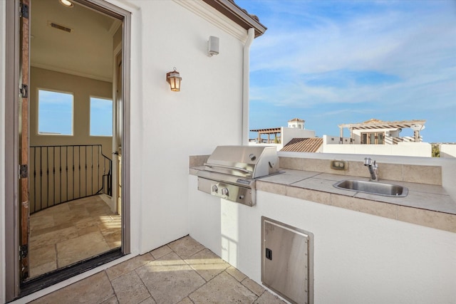 view of patio featuring an outdoor kitchen, area for grilling, and sink