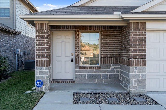 entrance to property with cooling unit and a garage