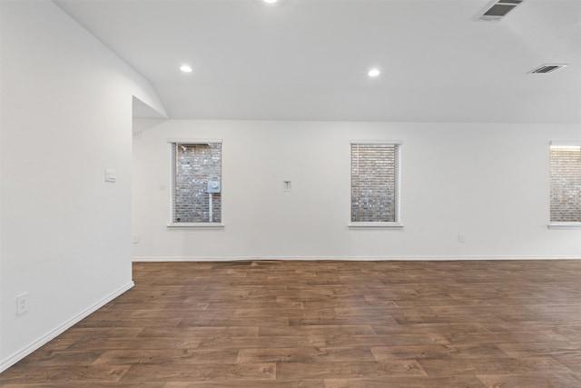 spare room featuring lofted ceiling and dark hardwood / wood-style floors