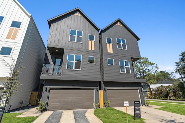 view of property featuring board and batten siding, driveway, a balcony, and a garage