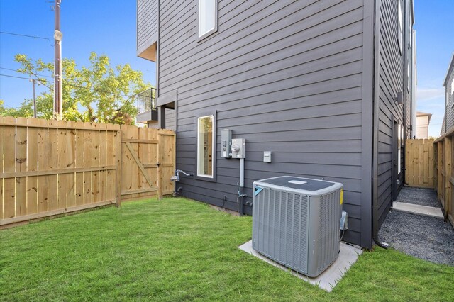 view of side of home featuring central AC unit and a lawn