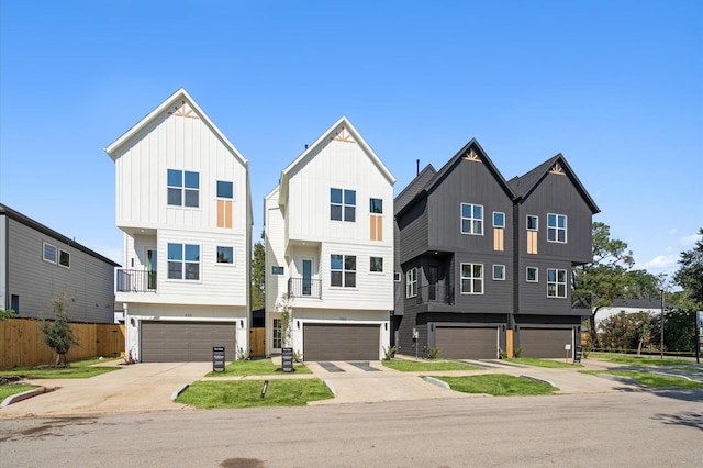 view of front facade featuring an attached garage, fence, and board and batten siding