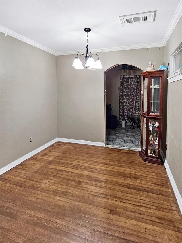 unfurnished dining area with crown molding, dark wood-type flooring, and a notable chandelier