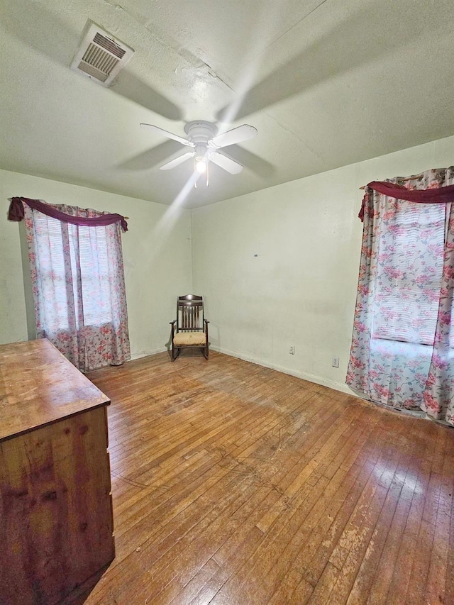 unfurnished room with wood-type flooring and ceiling fan