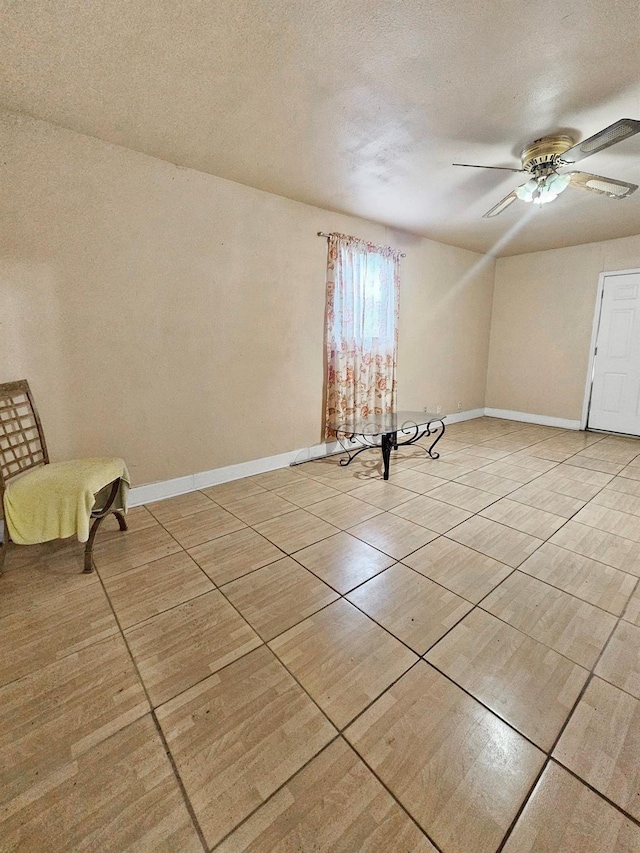 unfurnished room with ceiling fan and a textured ceiling