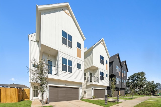 view of property featuring a front yard, a balcony, and a garage