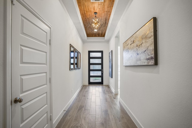 doorway to outside with a tray ceiling and dark hardwood / wood-style floors