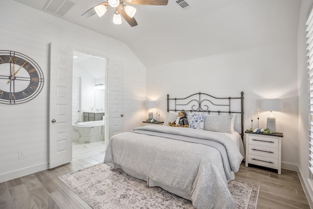bedroom with ceiling fan, ensuite bathroom, and lofted ceiling