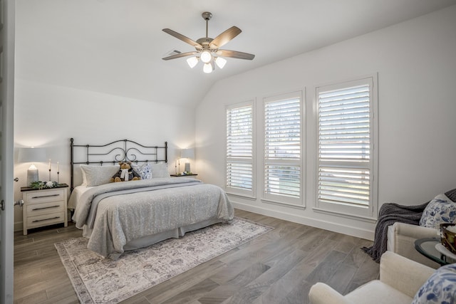bedroom with ceiling fan, lofted ceiling, and wood-type flooring